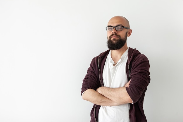 Portrait of a confident bearded bald handsome man in plaid shirt on white background