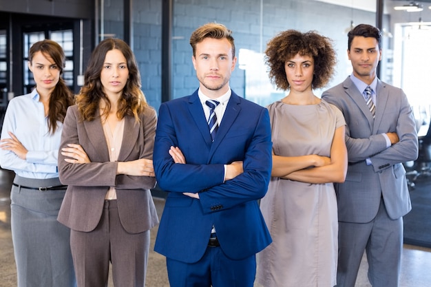 Portrait of confident business  team standing in office with their hands crossed