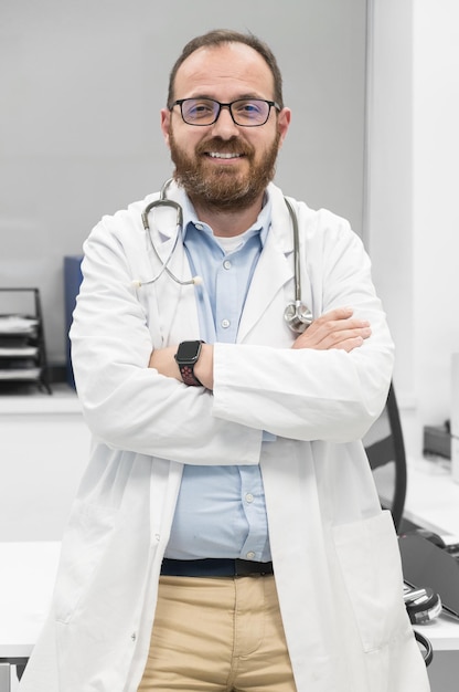 Portrait of confident doctor crossing hands and smiling at camera