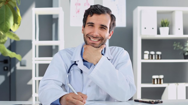 Portrait of confident doctor at desk in his medical practice