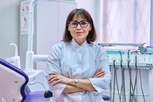 Portrait of confident female dentist doctor in office looking at camera