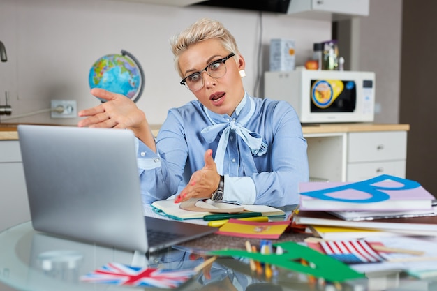 Portrait of confident good looking teacher sitting at table