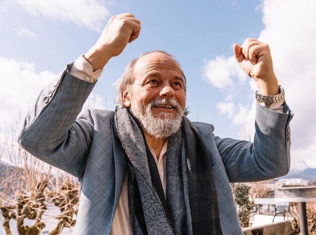 Portrait of a confident handsome happy mature man pensioner grandfather in the small town