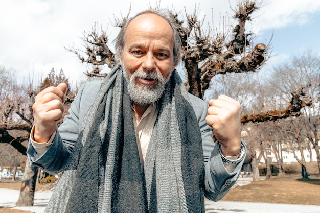 Portrait of a confident handsome mature man pensioner grandfather calling someone on the phone