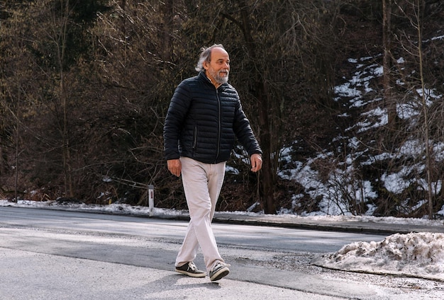 Photo portrait of a confident handsome mature man pensioner grandfather in the forest