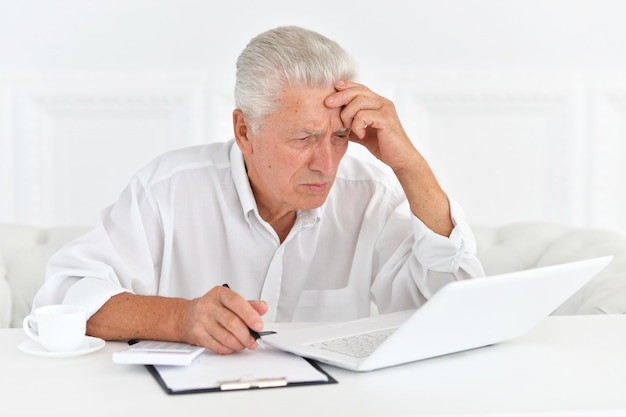 Portrait of confident senior businessman with laptop