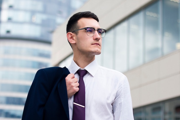 Portrait of a confident successful businessman in glasses and suit outdoors.