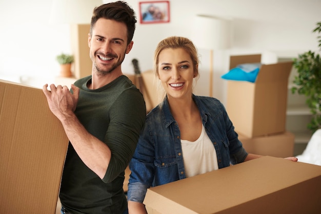 Portrait of couple holding cardboard boxes