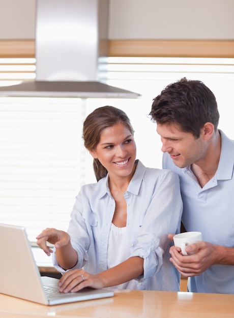 Portrait of a couple using a laptop while having tea