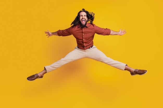 Photo portrait of crazy careless guy jump make star shape on yellow background