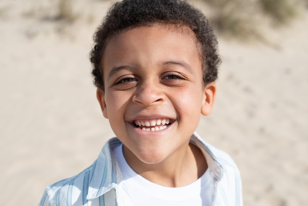 Portrait of cute African American boy. Male model with curly hair looking at camera, smiling. Portrait, beauty concept