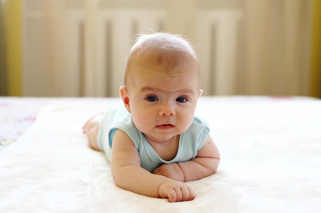 Portrait of cute baby boy on bed