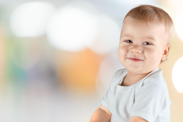 Portrait of cute baby boy on blurred background