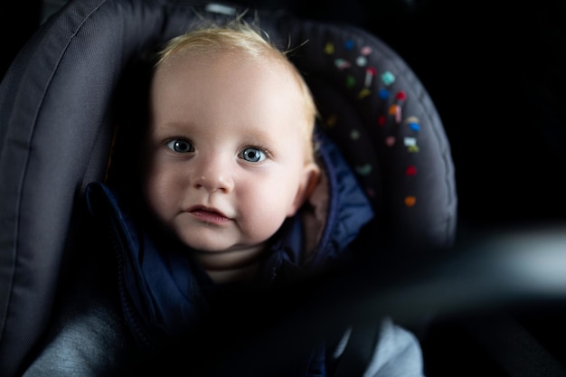 Portrait of a cute baby in a car seat in a car