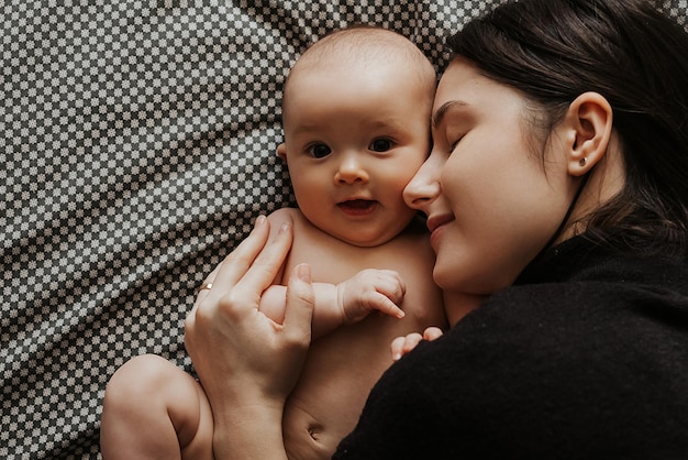 Portrait of a cute baby and her mom holding a baby in her mother's arms