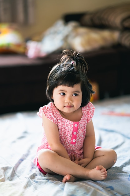 Portrait of cute baby sitting on the bed