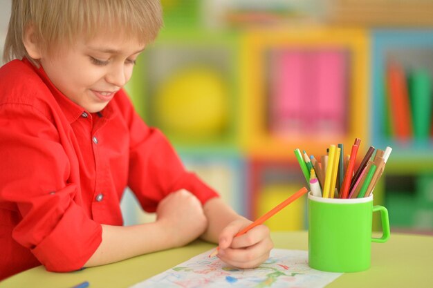 Portrait of cute boy drawing with pencils