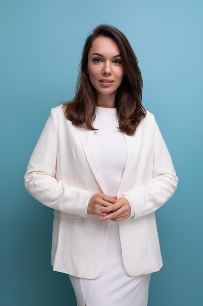 Portrait of a cute brunette woman in a white dress with pleasant features