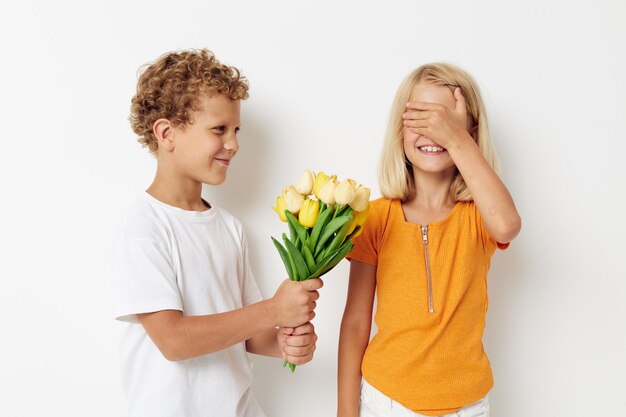 Portrait of cute children fun birthday gift surprise bouquet of flowers lifestyle unaltered