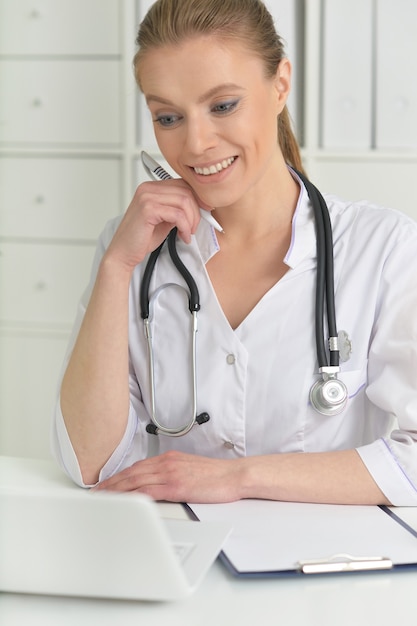 Portrait of  cute female doctor with laptop