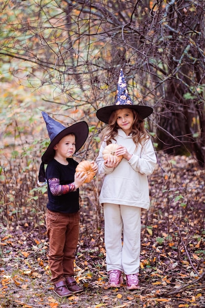 Portrait of a cute funny kids posing with pumpkins