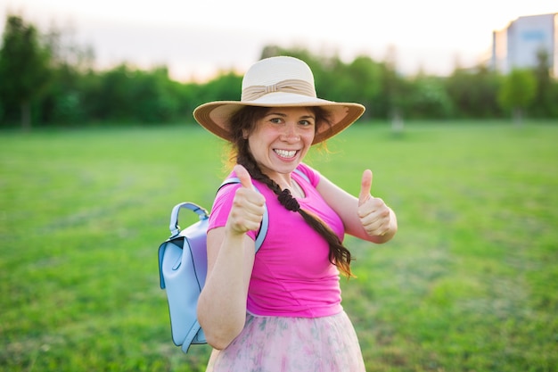 Portrait on cute funny laughing or surprised woman with backpack and hat