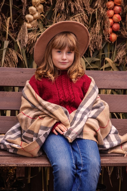 portrait of a cute girl in autumn near the house