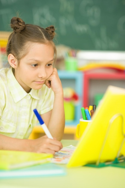 Portrait of a cute girl doing homework