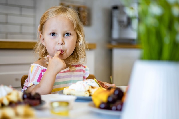 Photo portrait of cute girl eating food at home