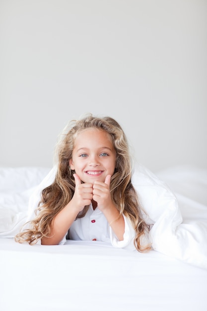 Portrait of a cute girl lying on a bed