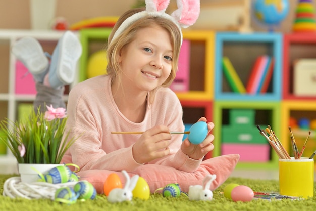 Portrait of a cute girl paint Easter eggs