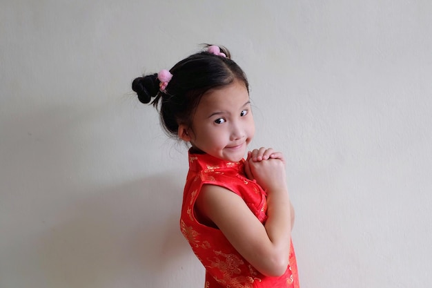 Portrait of cute girl standing against wall