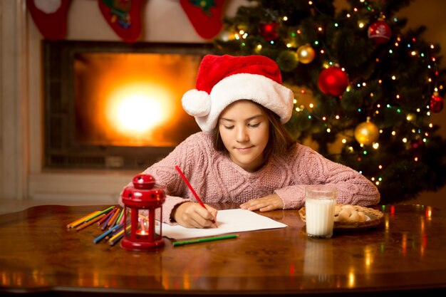 Portrait of cute girl writing letter to Santa at living room