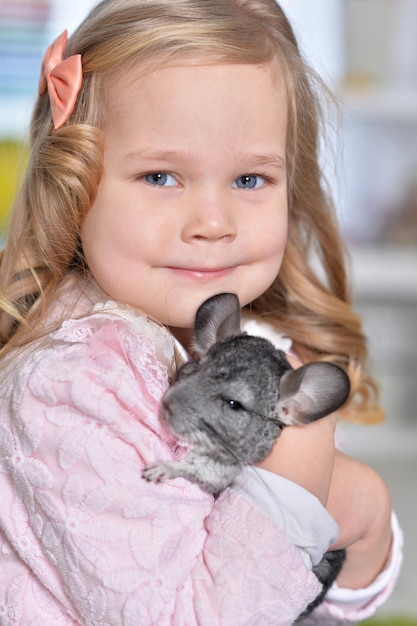 Portrait of a cute little girl playing with chinchilla