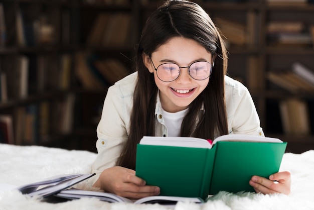 Portrait of cute little girl reading a book