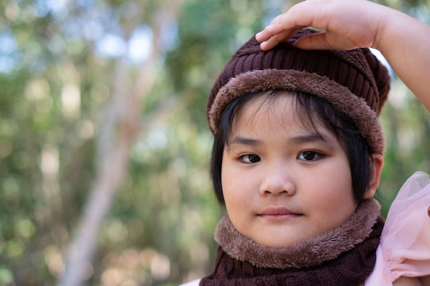 Portrait of a cute little girl in wool hat on blurred background