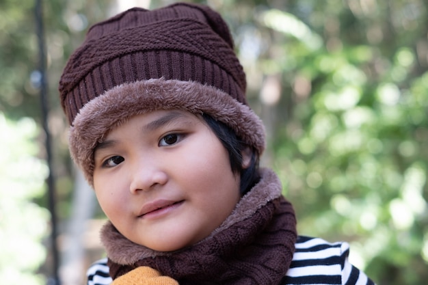 Portrait of a cute little girl in wool hat on blurred background