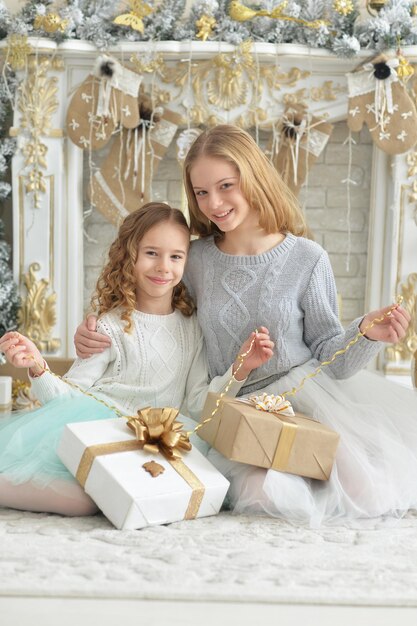 Portrait of cute little girls with gift posing