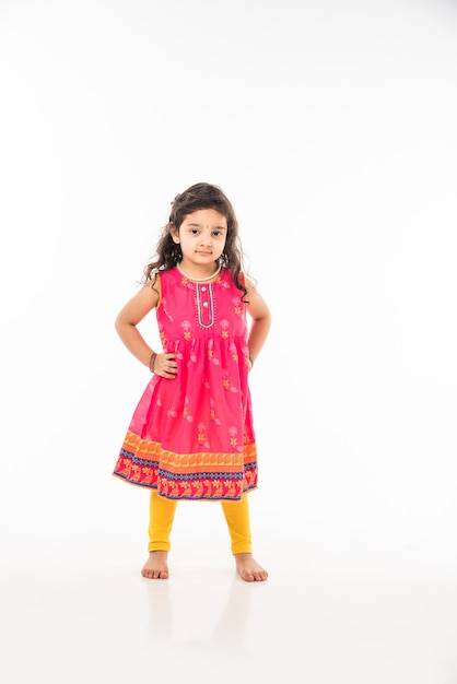 Portrait of cute little Indian girl model, sitting isolated over white background