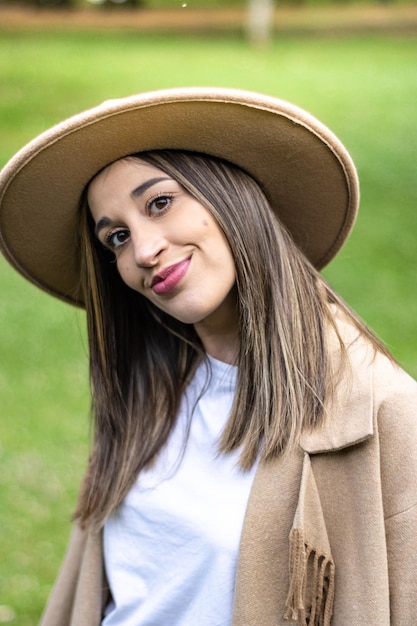 Portrait of cute smiling girl in hat outdoors Close up of young woman in hat smiling at camera on grass Face of smiling girl in hat on the grass