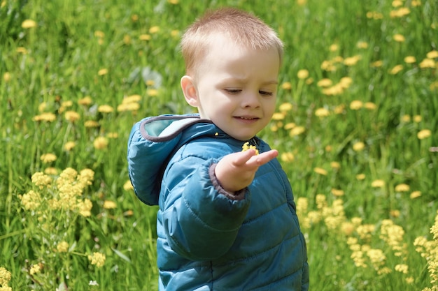 Portrait of cute toddler boy in spring blooming meadow