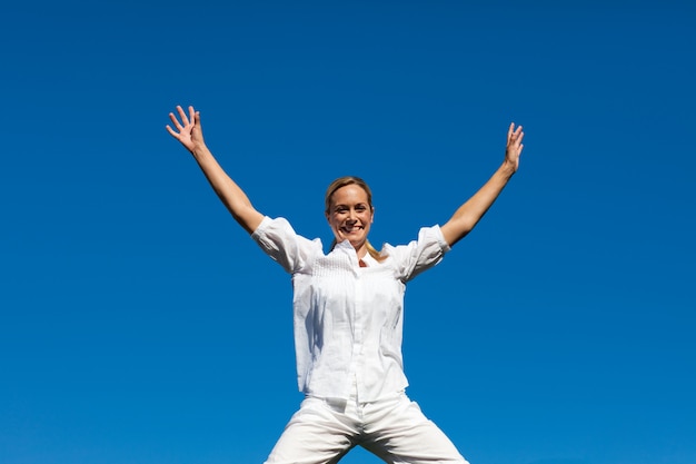 Portrait of a cute woman jumping in the air outdoor 