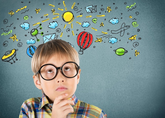 Portrait of a cute young boy in  glasses thinking over background