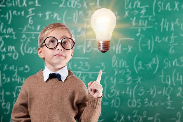 Portrait of a cute young boy in  glasses thinking over background