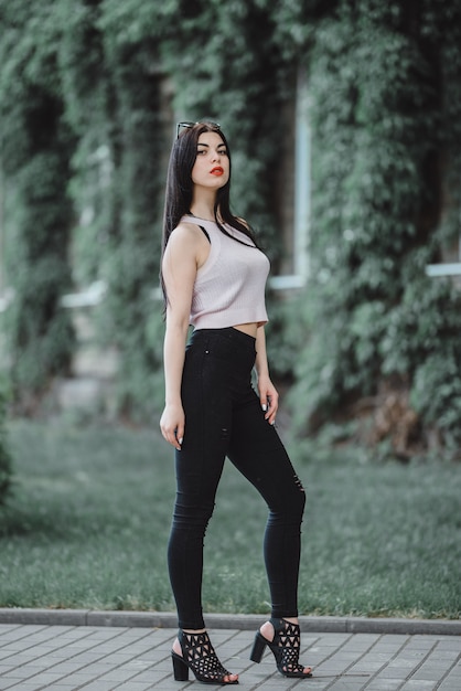 Portrait of a cute young brunette with red lips and in a white T-shirt 