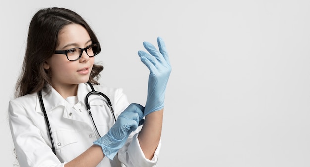 Portrait of cute young girl with surgical gloves