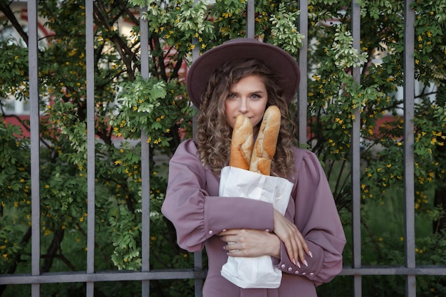 Portrait cute young woman in French style with baguettes in hands