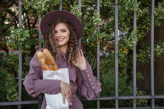 Portrait cute young woman in French style with baguettes in hands