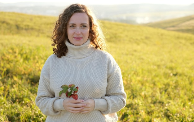 Portrait of  Dark Haired curly Woman Smiling while Standing in  field landscape