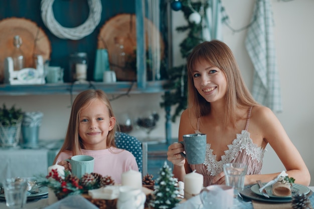 Portrait of daughter with mother eating breakfast at home